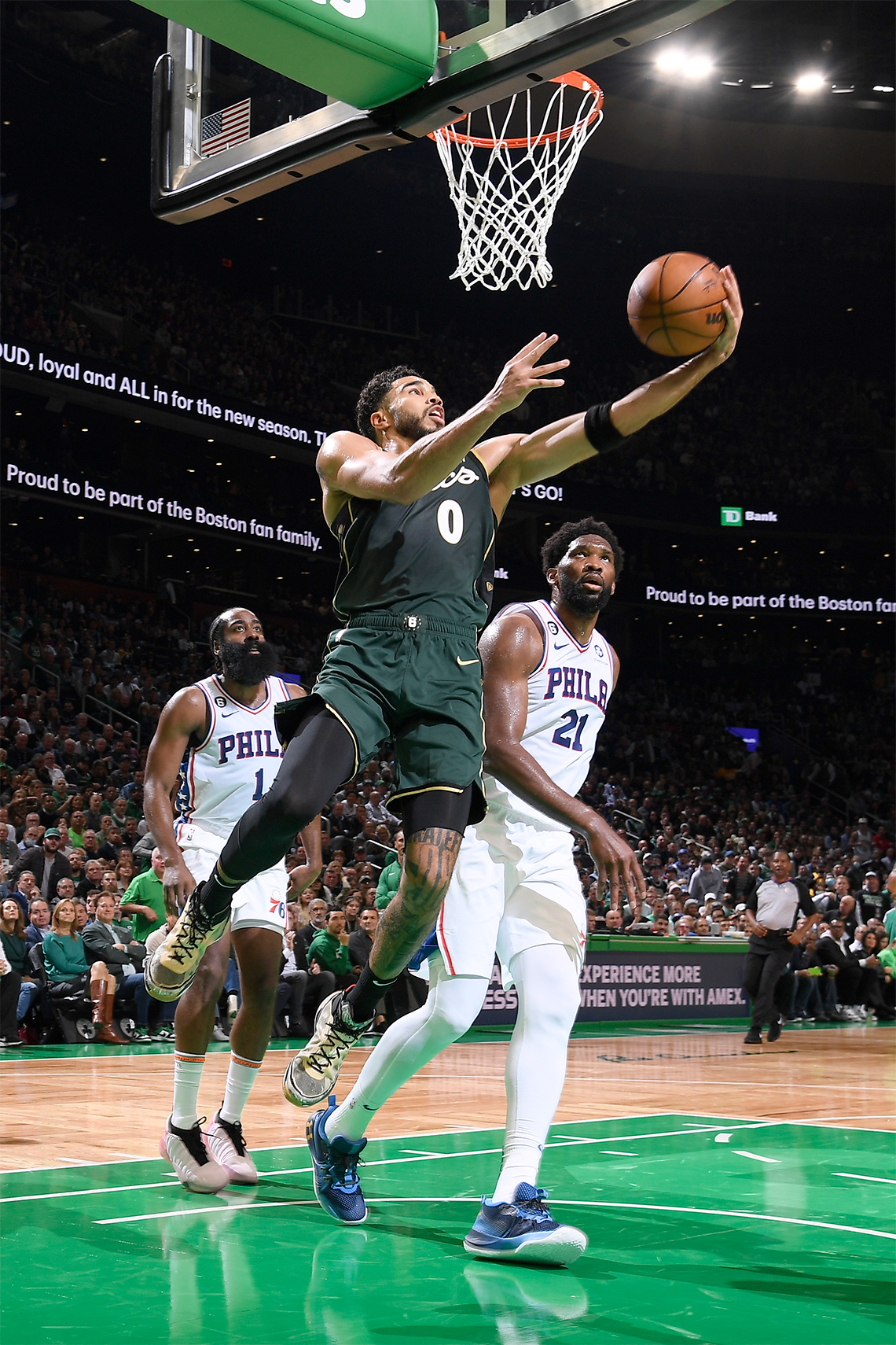 Jayson Tatum, #0 of the Boston Celtics (2022) jumps and throws the basketball into the net, while opposing players look on.