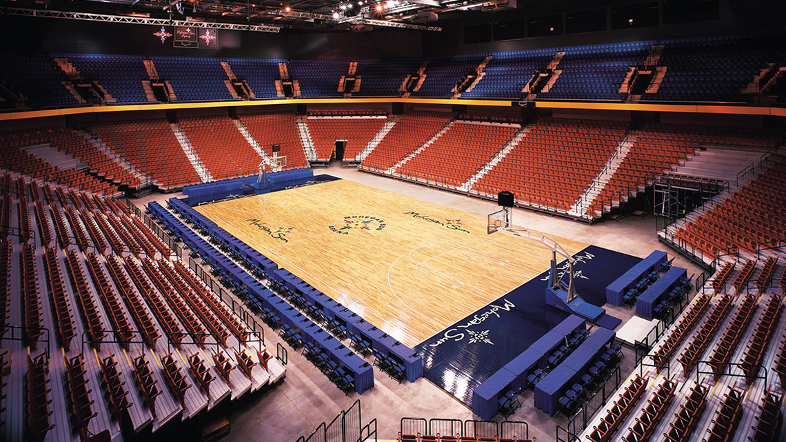 Basketball court in Mohegan Sun Arena entirely light with empty seating.
