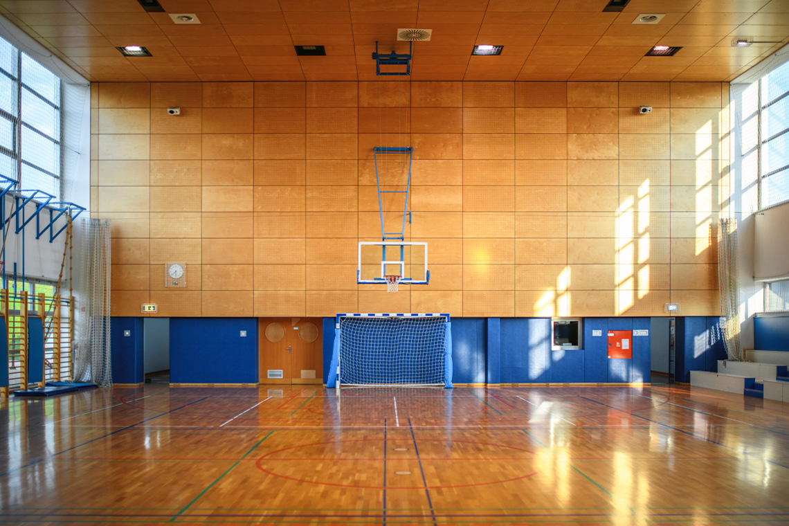 Basketball court in a gym. Court is empty and well lit.