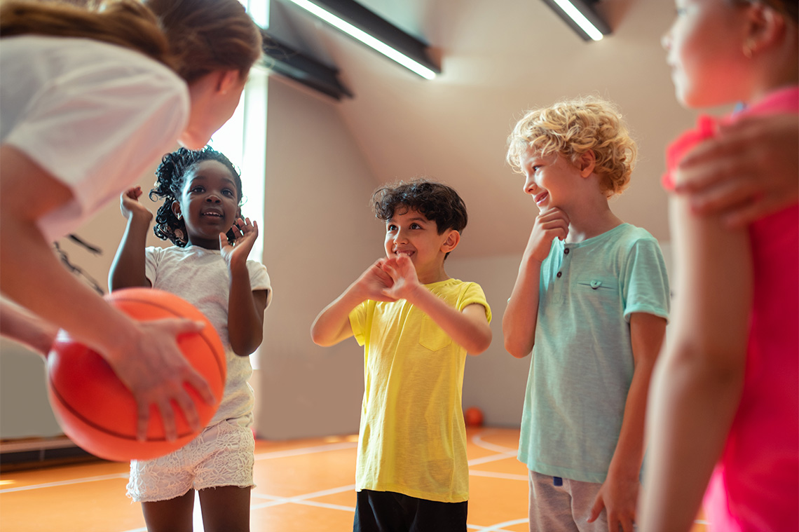 Students in a group smiling at their sports teacher.