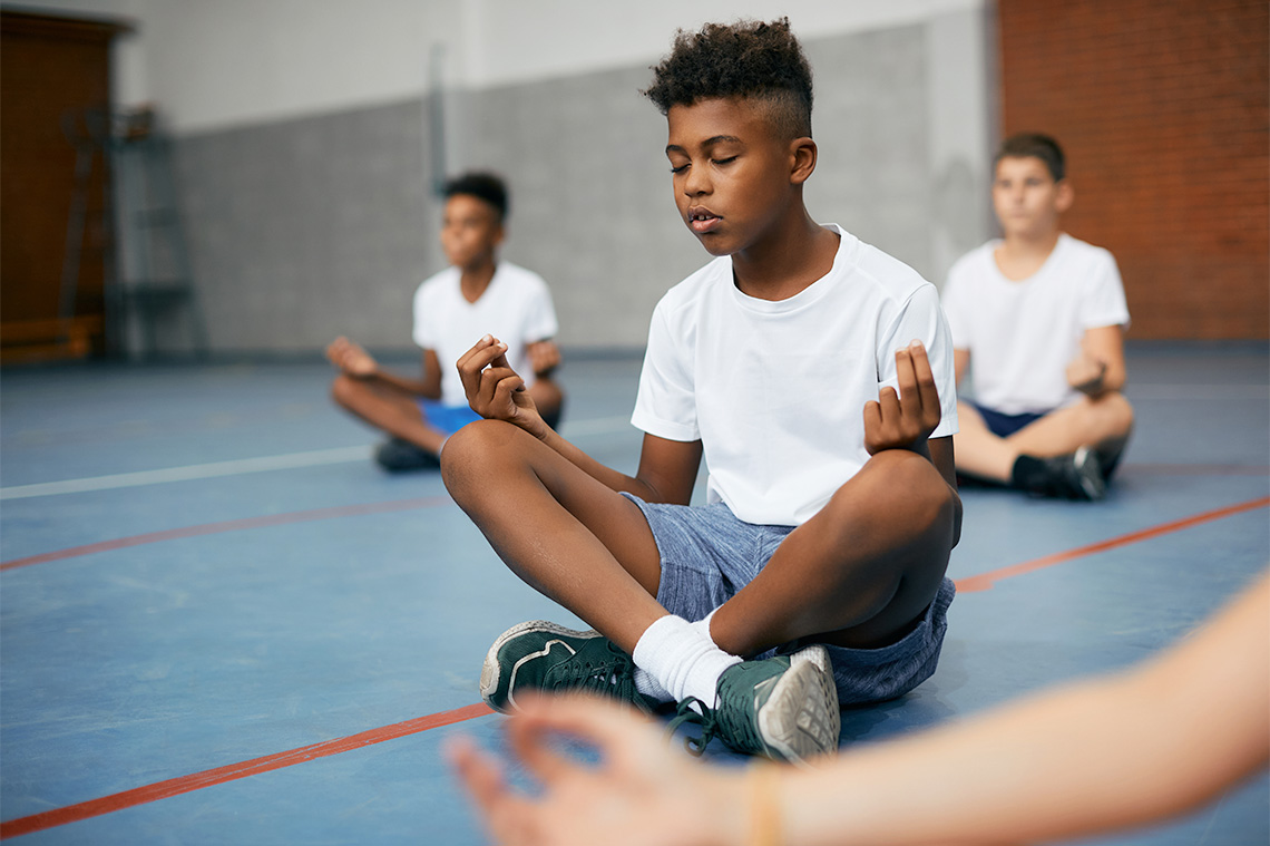 Group of students seated and focusing on their breathing.