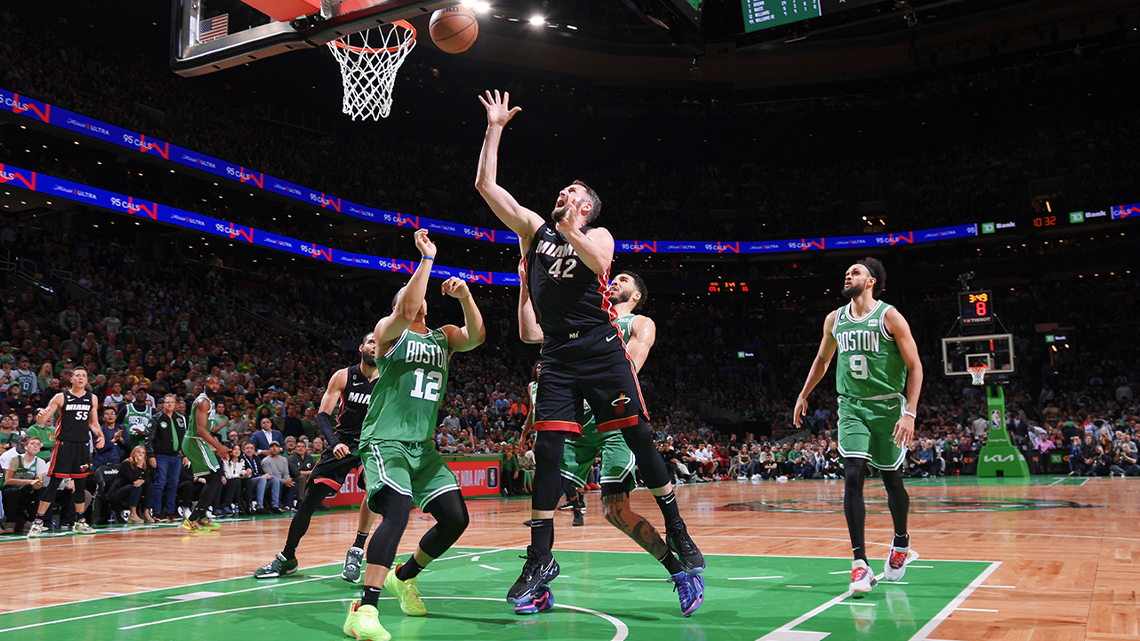 Kevin Love, #42 of the Miami Heat (2023) jumps and throws the basketball into the net, while opposing players look on.